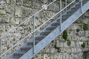 Modern metal staircase close-up against the background of an ancient building photo