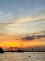 A sunset view of a river and a river with clouds in the sky photo
