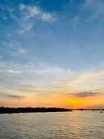 A sunset view of a river and a river with clouds in the sky photo