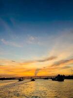 A sunset view of a river and a river with clouds in the sky photo