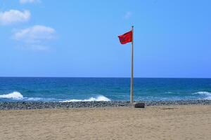 Red flag on the beach of Gran Canaria. Swimming is prohibited photo