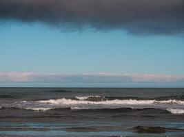 Sea with waves at dusk under a cloudy sky, Gran Canaria. Seascape background wallpaper with copy space photo