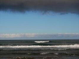 Sea with waves at dusk under a cloudy sky, Gran Canaria. Seascape background wallpaper with copy space photo