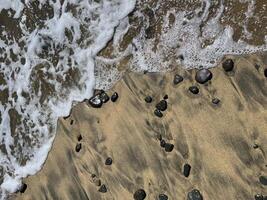 Sea water foam on the shore with sand and pebbles. Abstract seascape background wallpaper with copy space photo