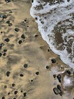 Sea water foam on the shore with sand and pebbles. Abstract seascape background wallpaper with copy space photo