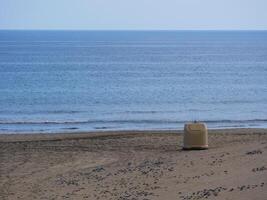 Garbage container on the beach of Gran Canaria. The concept of cleanliness, ecology and environmental care photo