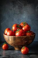 A bowl of ripe, red tomatoes on a dark background. photo