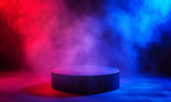 A black cylindrical podium in a dark room illuminated by red and blue smoke. photo