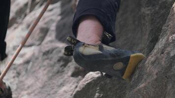 Tyrnyauz, Russia - 10 Jun 2024. A climber deftly secures a foothold on rugged rock formations during a challenging ascent at a climbing site in the late afternoon video