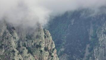 Majestic clouds gracefully drifting over a towering mountain peak video