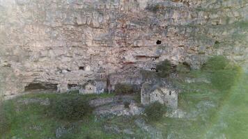 Aerial zoom in view Horomayr Monastery monastic complex in the Lori Province of Armenia, Odzun village. Monastery nestled amongst rock and cliff escarpments with caves for protection video