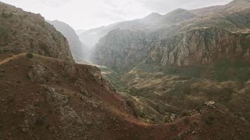 Flight over the ancient Noravank monastery in the mountains of Armenia. Fast motion fpv zoom out revealing view video