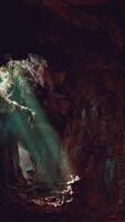 A mesmerizing green light shining through the entrance of a mystical cave video