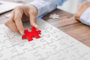 Hand push last piece jigsawto finish success planning concept solve puzzle, logical thinking, Concept of challenge and determination as the person works to complete the puzzle. photo