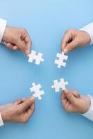 Business team holding parts of jigsaw puzzle trying to find solution to problem together. Concept of challenge and determination as the person works to complete the puzzle. photo