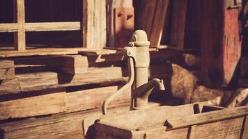 Old fashioned water pump in a rustic wooden setting during bright daylight video