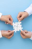 Business team holding parts of jigsaw puzzle trying to find solution to problem together. Concept of challenge and determination as the person works to complete the puzzle. photo