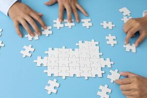 Business team holding parts of jigsaw puzzle trying to find solution to problem together. Concept of challenge and determination as the person works to complete the puzzle. photo