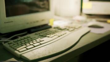 Old computer keyboard and monitor on a cluttered desk in an office setting video