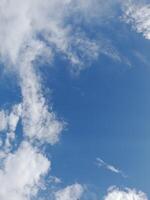 Beautiful white clouds on deep blue sky background. Large bright soft fluffy clouds are cover the entire blue sky. photo