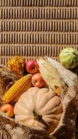 A rustic autumn harvest display with pumpkins, corn, and apples symbolizes Thanksgiving and seasonal abundance photo