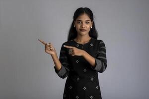 Beautiful girl holding and presenting something in the hand with a happy smiling face. photo
