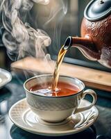 Tea Being Poured into a Steaming Teacup Indoors photo