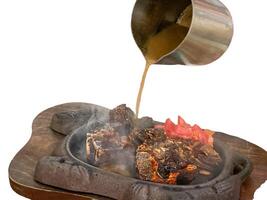 grilled ribs on hot plate isolated white background photo