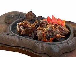 grilled ribs on hot plate isolated white background photo
