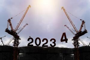 Silhouette of construction worker with crane and cloudy sky for preparation of welcome 2024 new year party and change new business. photo