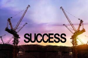 Build up success concept. Black alphabetic letters forming the word success being set up by group of construction machines. photo