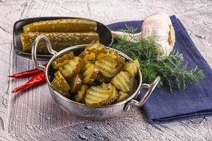 Sliced marinated cucumbers in the bowl photo