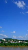 Blue sky with cumulus cloud vertical time lapse at a river on a sunny day. video