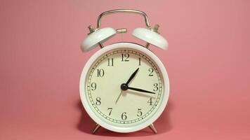 Vintage metal alarm clock on a pink background time lapse , ringing loudly to wake you up in the morning. video