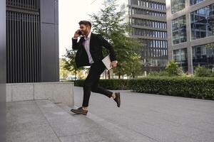 Businessman run and hurry up to office while talking phone with customers photo