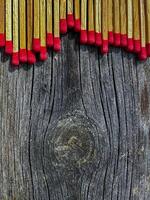 A closeup of matches scattered on a rustic wooden surface, showcasing the rich texture and warm colors. Perfect for themes of safety and simplicity. photo