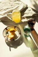 a table with a glass of lemonade and a plate of lemons photo