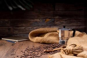 The picture of coffee beans stacked together on a wooden floor in a warm, light atmosphere, on a dark background, with copy space. photo
