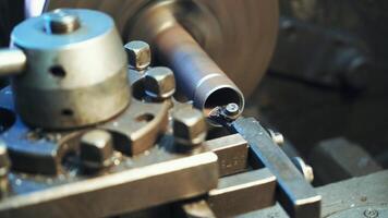 A metal part rotates and sharpeners on the lathe in the workshop in the manufacturing. Close-up. video