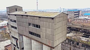 Flight over the empty old plant almost ruined in the city after the war. Old abandoned buildings without windows are broken-down. Camera moves around video