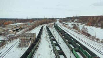 Long rows of containers stand on rails on the territory of the railway. Shipping. Camera motion to back. Aerial view. video
