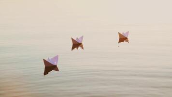 Three white paper ships floating in the river at sunset. Small childish paper boats swim in the lake with their reflection in the calm water. video