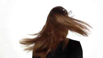 Graceful model with gorgeous hair poses for the camera in the studio on a white background. Close-up video