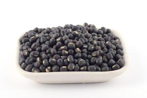Urad dal, black gram, Vigna mungo in white plate on white background photo