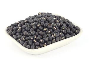 Black beans in a white bowl on a white background photo
