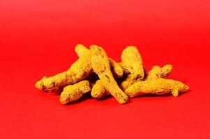 Turmeric root on red background photo