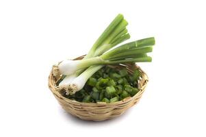 Fresh ripe green spring onions shallots or scallions with chopped onions in basket on white background photo