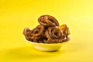 A bowl of caramel on a yellow background photo