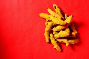 A pile of dried ginger on a red background photo
