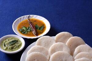 A plate of food with a bowl of soup and a spoon photo